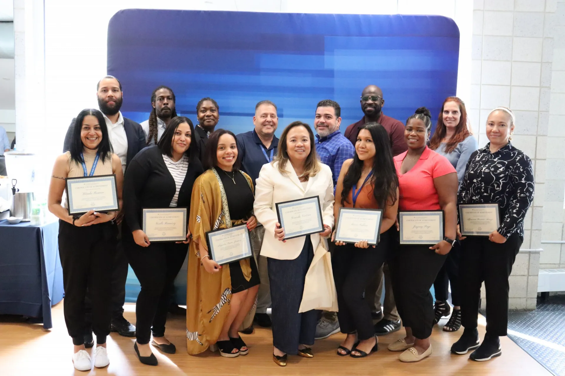 A group of people gather together holding certificates.