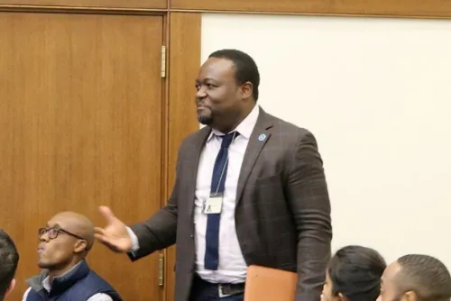 Lamaka Opa stands and asks a question during a seminar meeting.