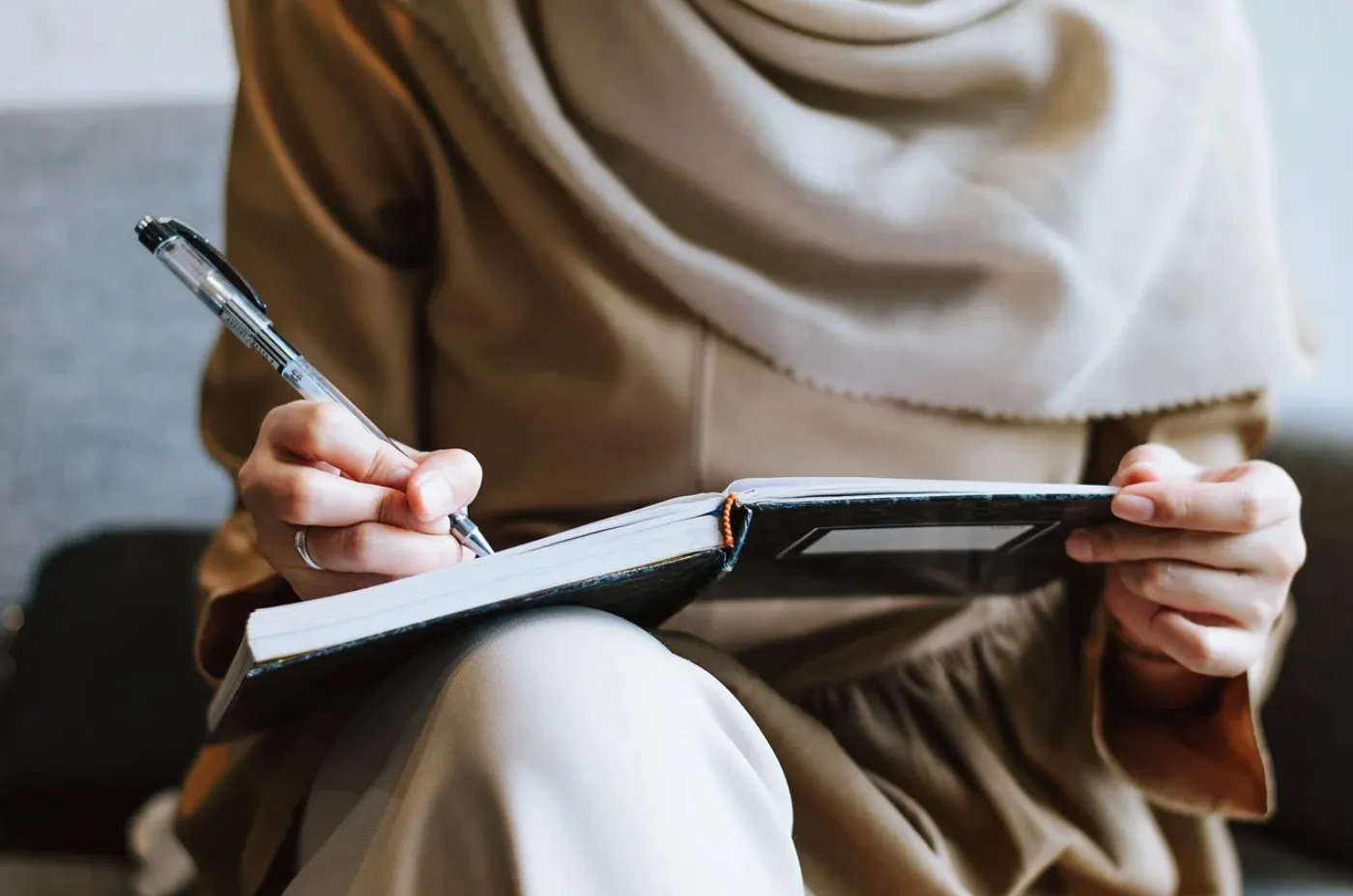 A person takes notes in their notebook.