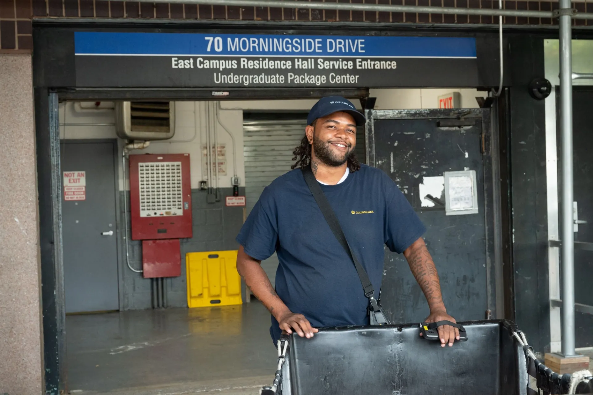 A Columbia Mail employee pushes a cart in front of the Undergraduate Package Center dock.