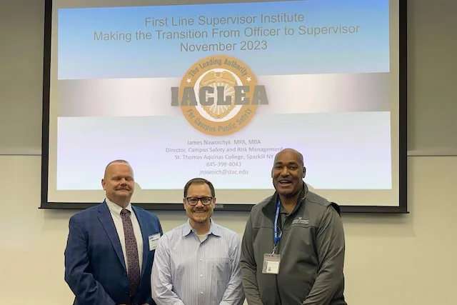 Gerald Lewis, VP of Public Safety, stands next to public safety training professionals at the IACLEA training conference.